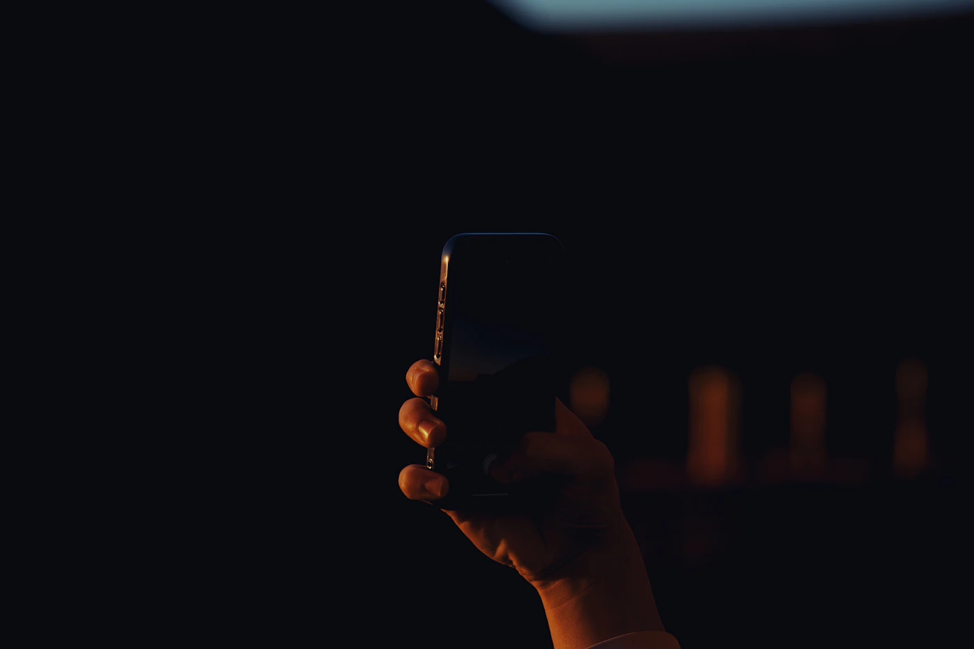 Main tenant un téléphone la nuit, illustrant le jeu de casino mobile